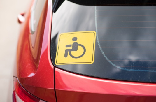 A handicap sticker in the rear window of a car - cheap car insurance in Georgia.