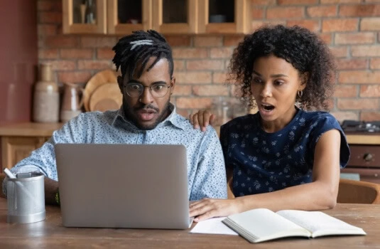 Young black couple checking online for their Georgia DMV record, finding a surprise - cheapest car insurance in Georgia.
