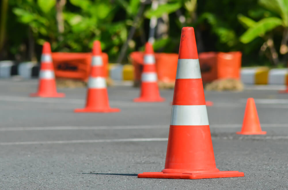 Defensive driving course practice area with orange traffic cones set up on a paved road, used for driver safety training and maneuvering exercises.