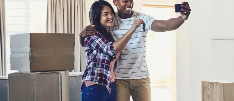 Happy couple, keys and selfie in new rental home for moving, rent in house with cheap renters insurance in Georgia.