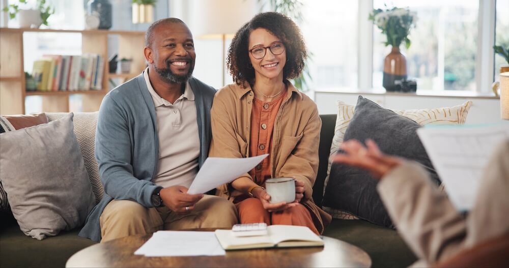 Insurance agent, meeting mature couple on sofa for estate planning, asset management or pension. Documents, life insurance and retirement paperwork with people at home for investment portfolio in Georgia.
