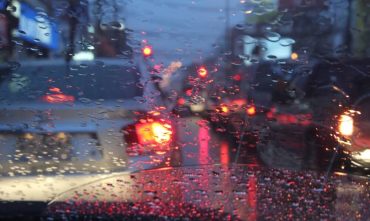 Cars drive through rainy night in Georgia, illustrating the need for comprehensive car insurance.