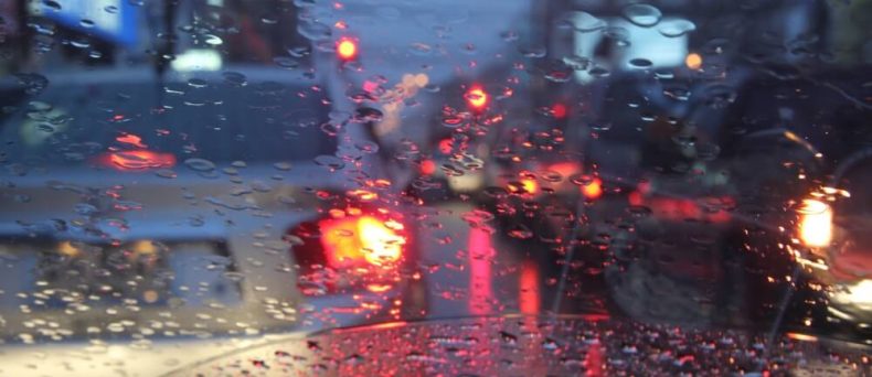Cars drive through rainy night in Georgia, illustrating the need for comprehensive car insurance.