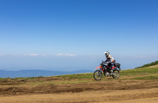 A motorcyclist in a full motorcycle suit rides Mount Gomi (Gomis Mta) in Georgia, showcasing motorcycle rides in Georgia.