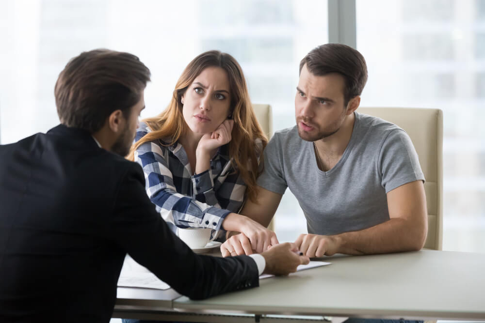 Upset couple discussing their rental dispute with a lawyer, seeking guidance on breaking a lease in Georgia