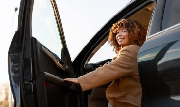 Woman getting into her car, highlighting the importance of checking your Georgia auto insurance status.