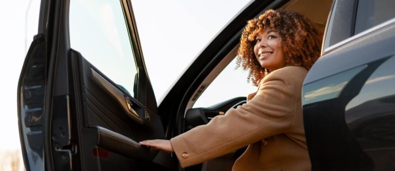 Woman getting into her car, highlighting the importance of checking your Georgia auto insurance status.