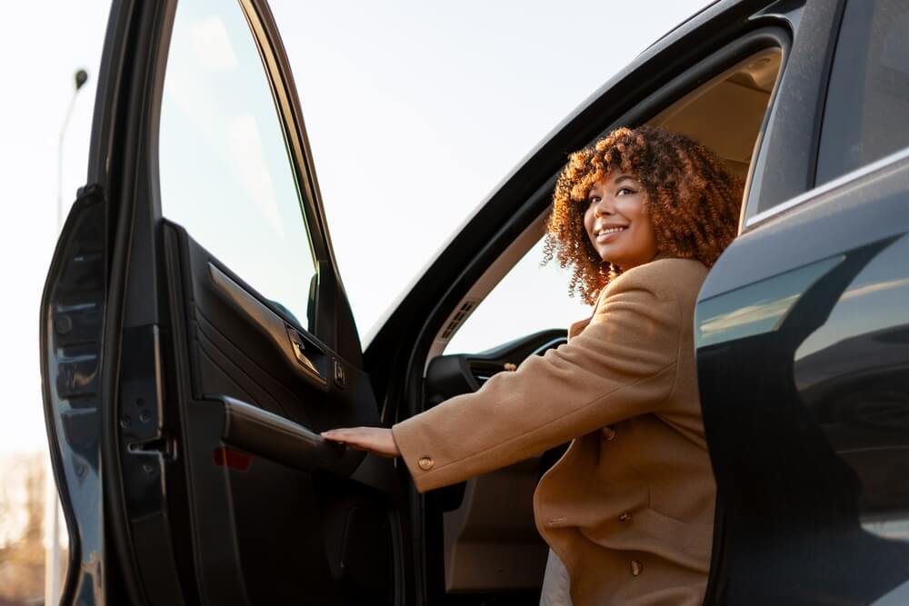 Woman getting into her car, highlighting the importance of checking your Georgia auto insurance status.