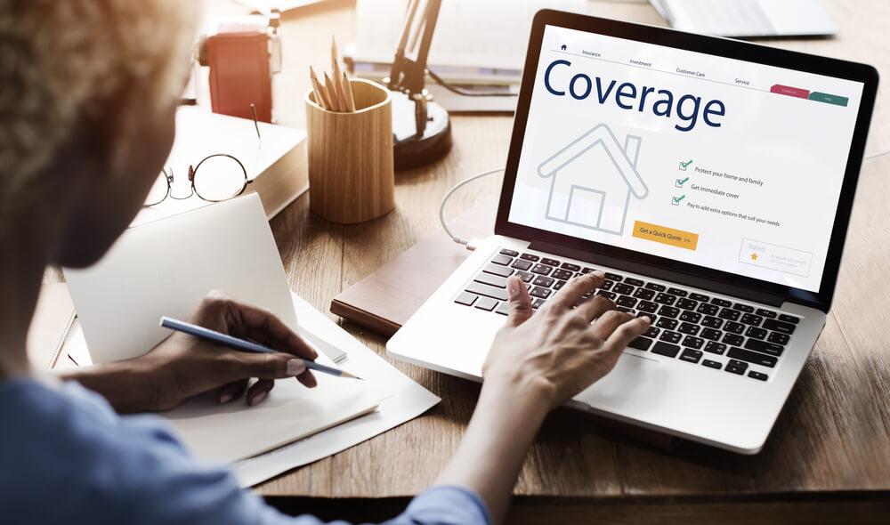 Person reviewing homeowners insurance coverage options on a laptop at a desk, representing protection for a home and detached garage.