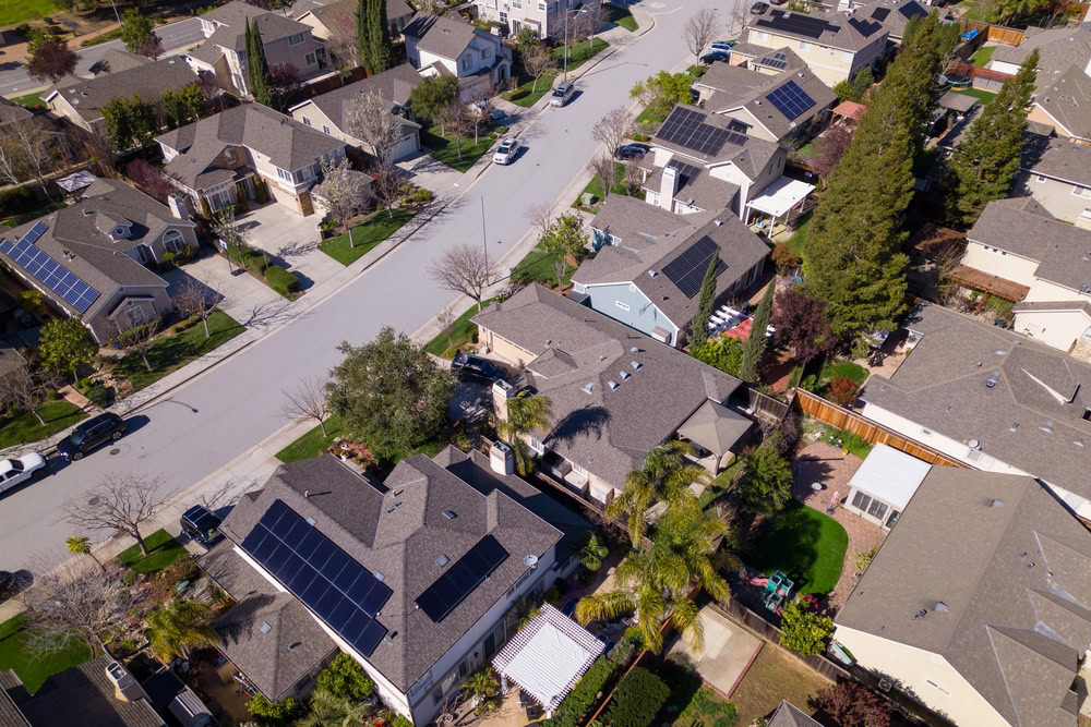 Neighborhood with homes featuring solar panels and home insurance coverage.