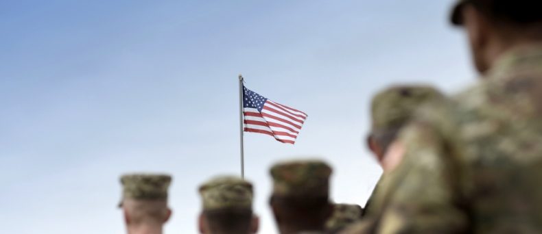Model car on stacks of coins with a calculator and insurance documents in the background.