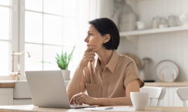 Woman reviewing information on her laptop at home after being denied homeowners insurance in Georgia.