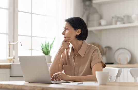 Woman reviewing information on her laptop at home after being denied homeowners insurance in Georgia.