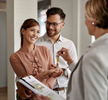 Happy young couple receiving home keys