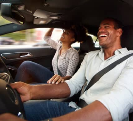 Smiling african american couple inside car driving