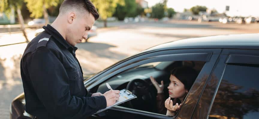 Cop writing a ticket to frustrated female diver in car