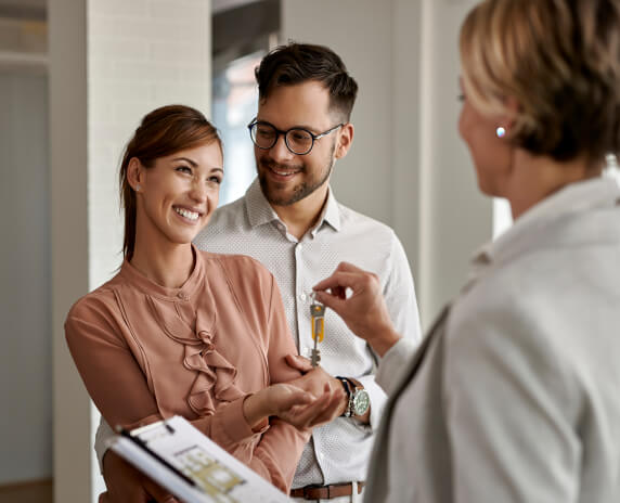 Happy young couple receiving home keys