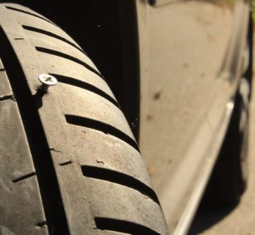 Closeup of a tire with a screw in the middle