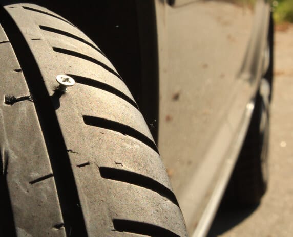 Closeup of a tire with a screw in the middle