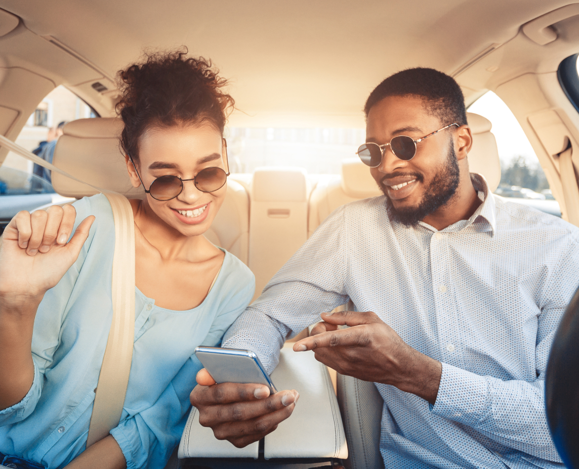 Young couple driving car and using digital map on smartphone, cheap car insurance in Georgia.