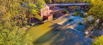 This is a shot taken by a drone of Praters Mill near Dalton Georgia. Looking down from above showing the dam and mill with a road crossing the stream.