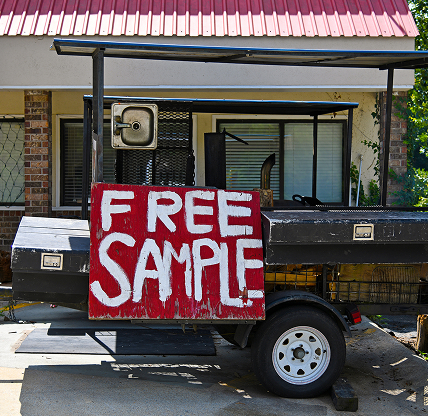 VILLA RICA, GA / USA - July 3, 2018: A Barbeque Grill in front of a local Restaurant with a Red Wooden Sign offering Free Sample.