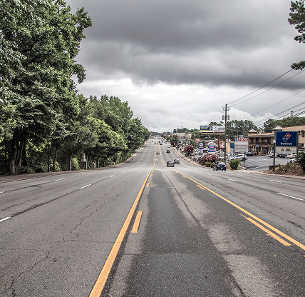 Snellville, Ga USA - 07 06 20: Traffic on a 7 lane highway with dark clouds above.