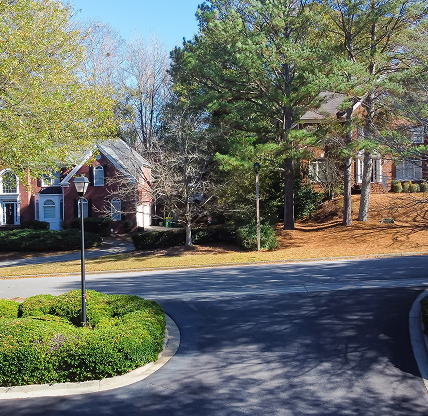 Quiet residential street with large homes and mature trees in a suburban neighborhood of South Fulton, Georgia