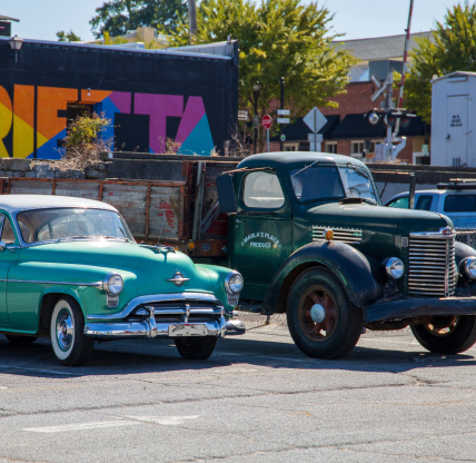 Marietta Georgia USA - 9 22 2023: a classic car and truck parked in the Marietta Square in front of colorful wall mural in Marietta Georgia USA